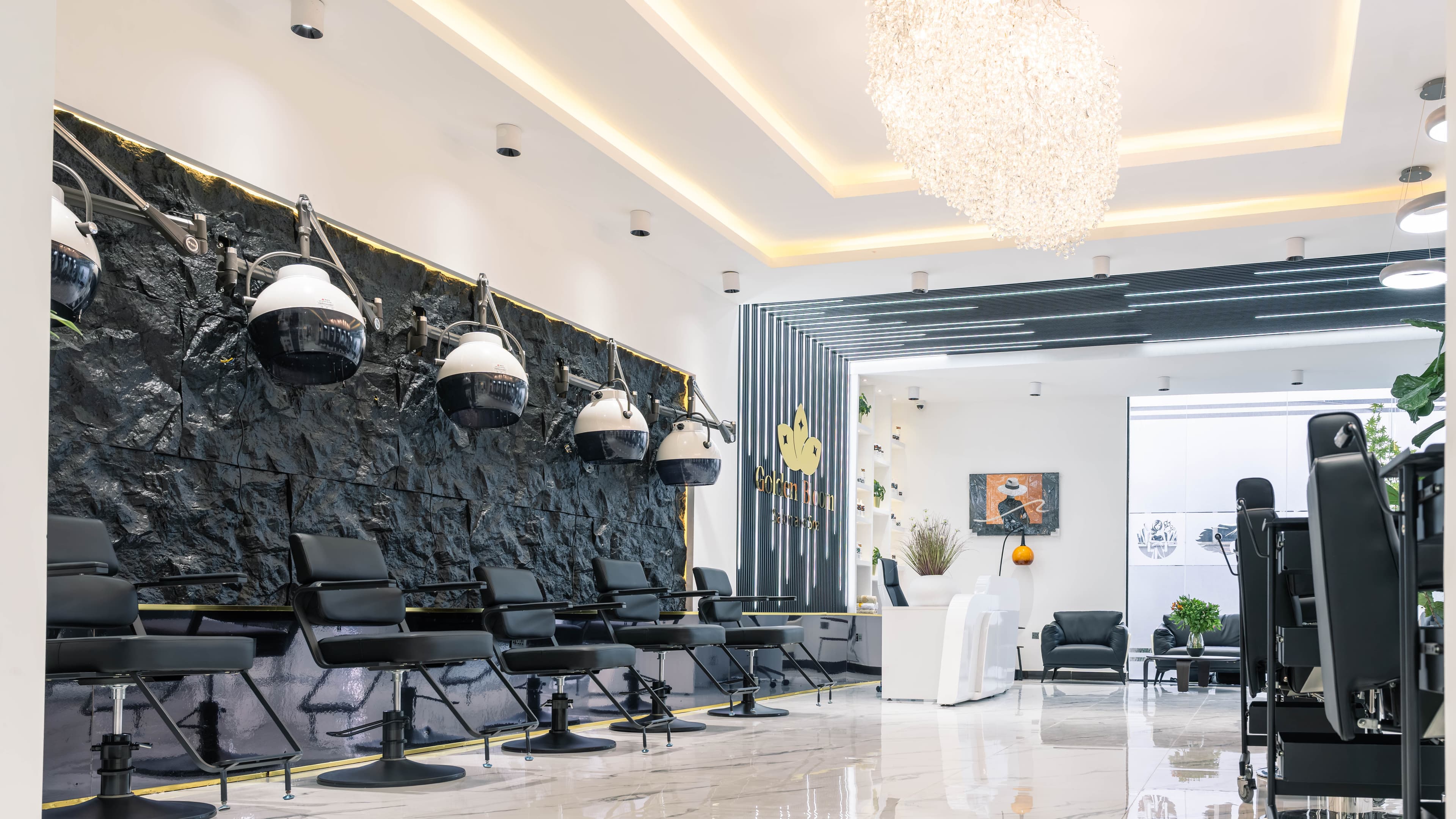 Main salon floor with styling stations under a gold-lit ceiling