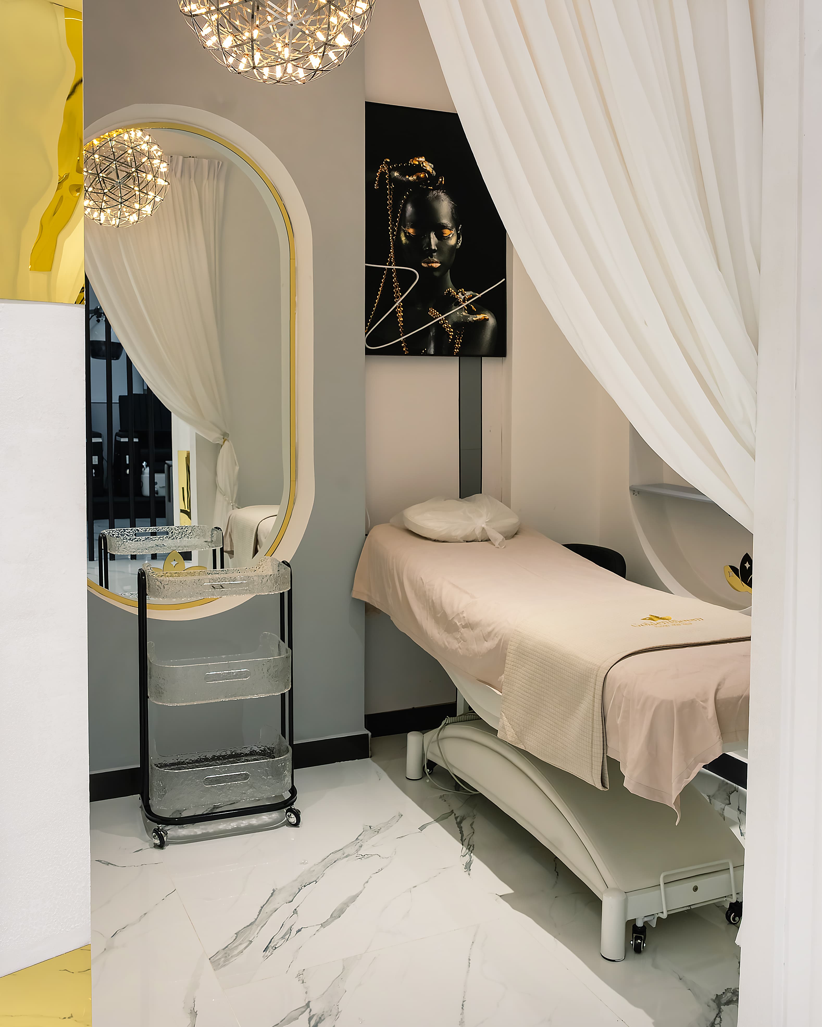 Treatment room with massage bed and arched shelving